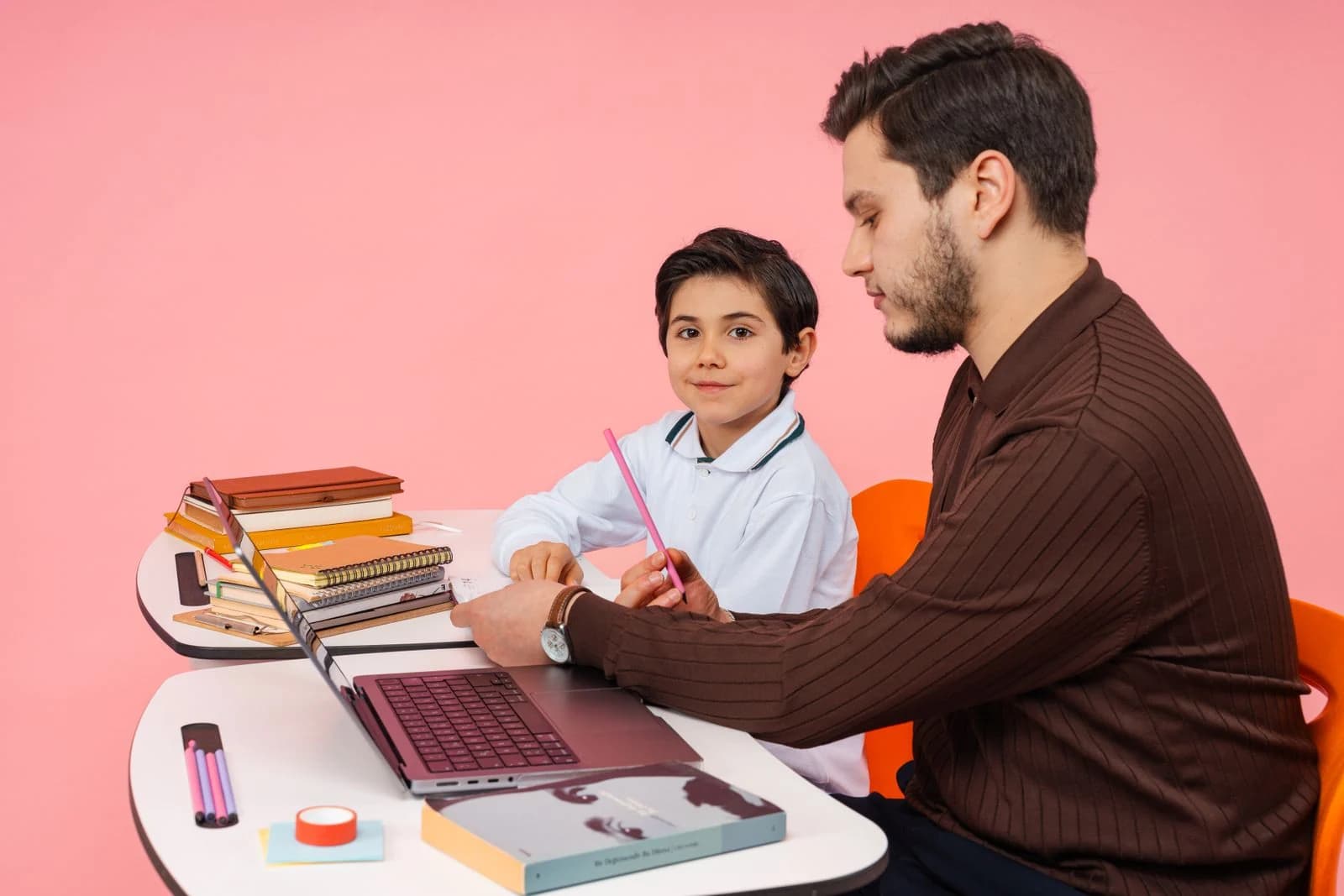 Teacher guiding a young student through schoolwork