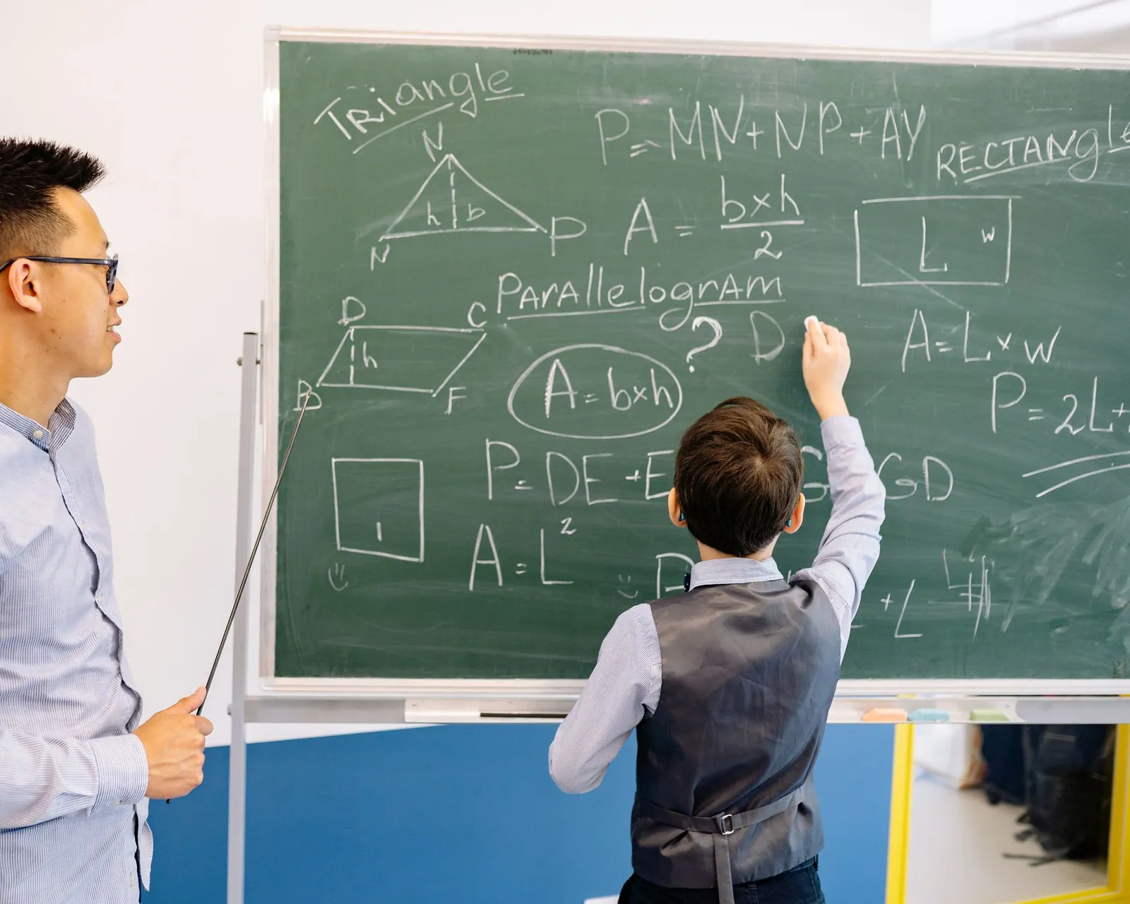Math tutor guiding a student through geometry at a chalkboard